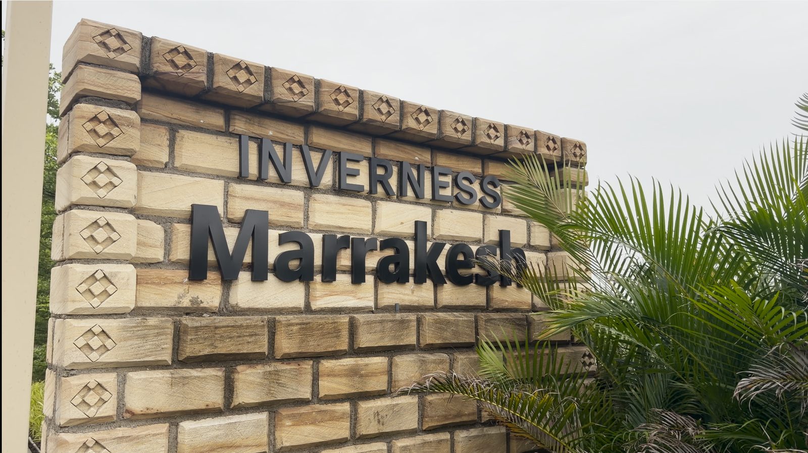 The stone entrance sign reading Inverness Marrakesh at the gated community in Sanand